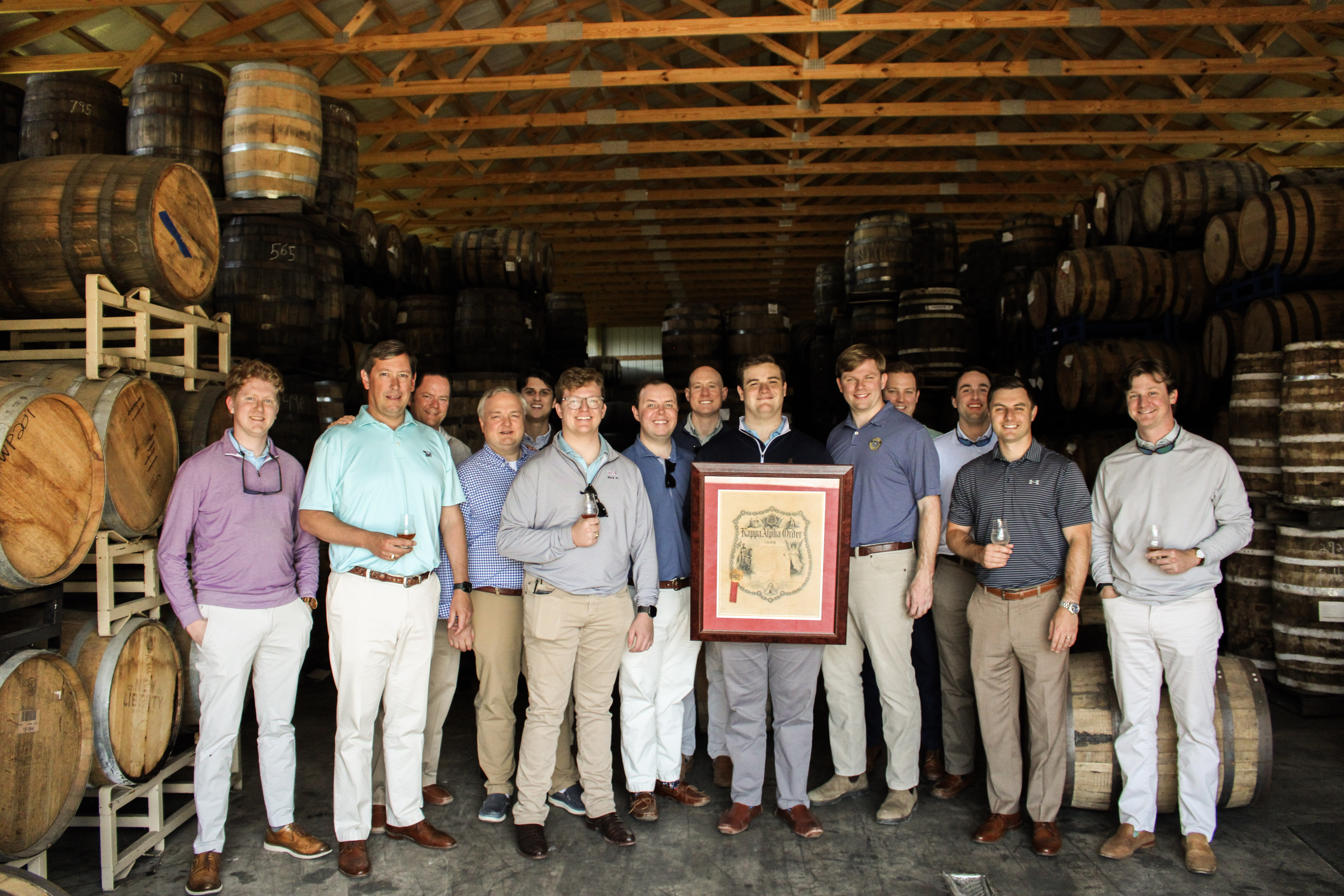 Alumni group at the barrel warehouse with their custom bourbon